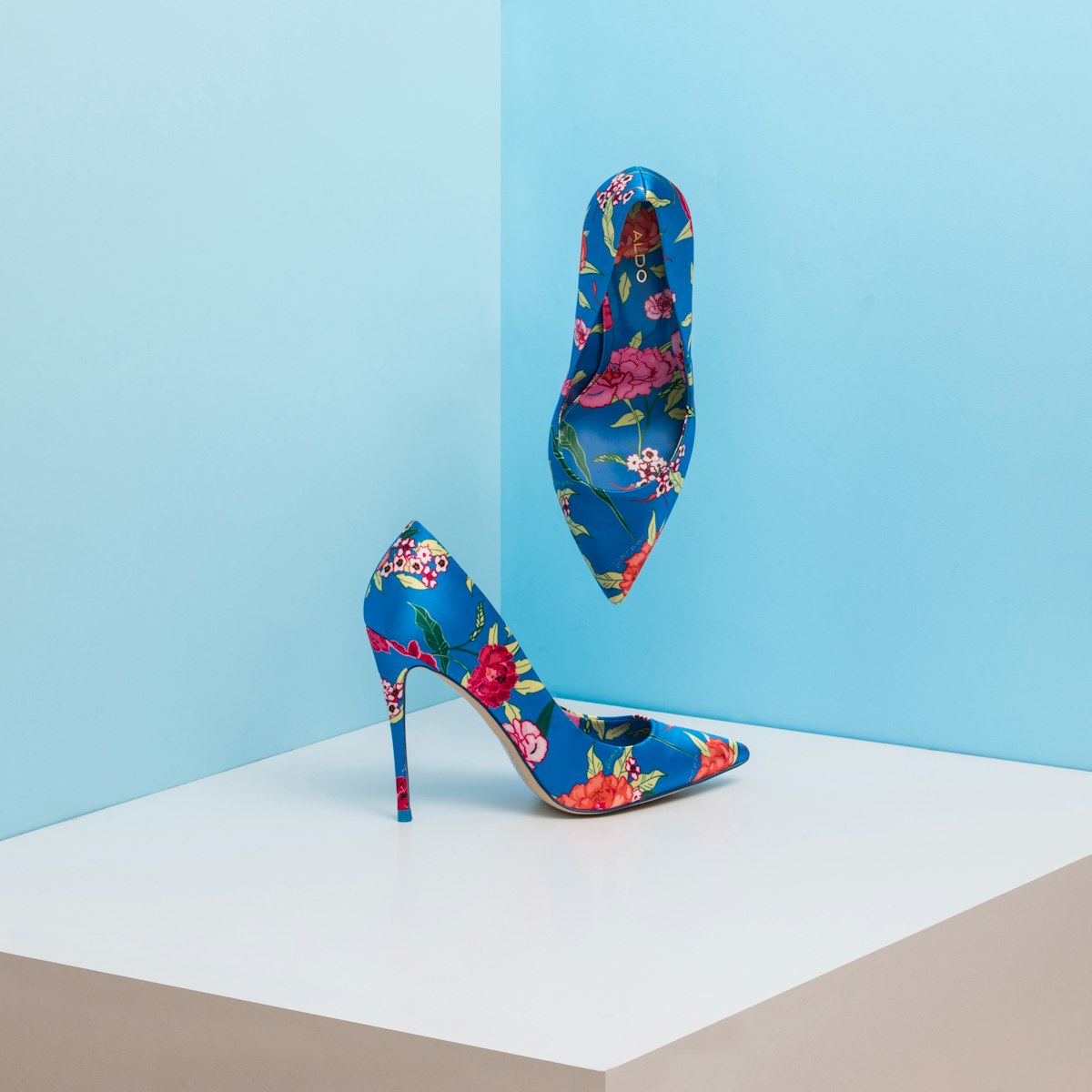 Patterned high-heeled shoes against a blue backdrop